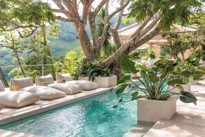 A pool area with a view of the mountains, surrounded by large potted plants and cushioned seating. - The Retreat Costa Rica - Wellness Resort & Spa (Jesús)