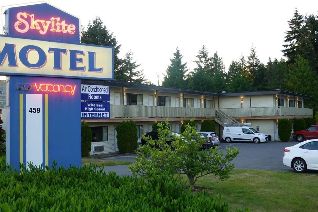Un motel con letrero de neón, habitaciones con aire acondicionado y servicio de internet de alta velocidad.