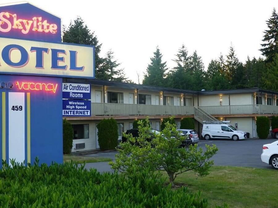 Un motel con letrero de neón, habitaciones con aire acondicionado y servicio de internet de alta velocidad.