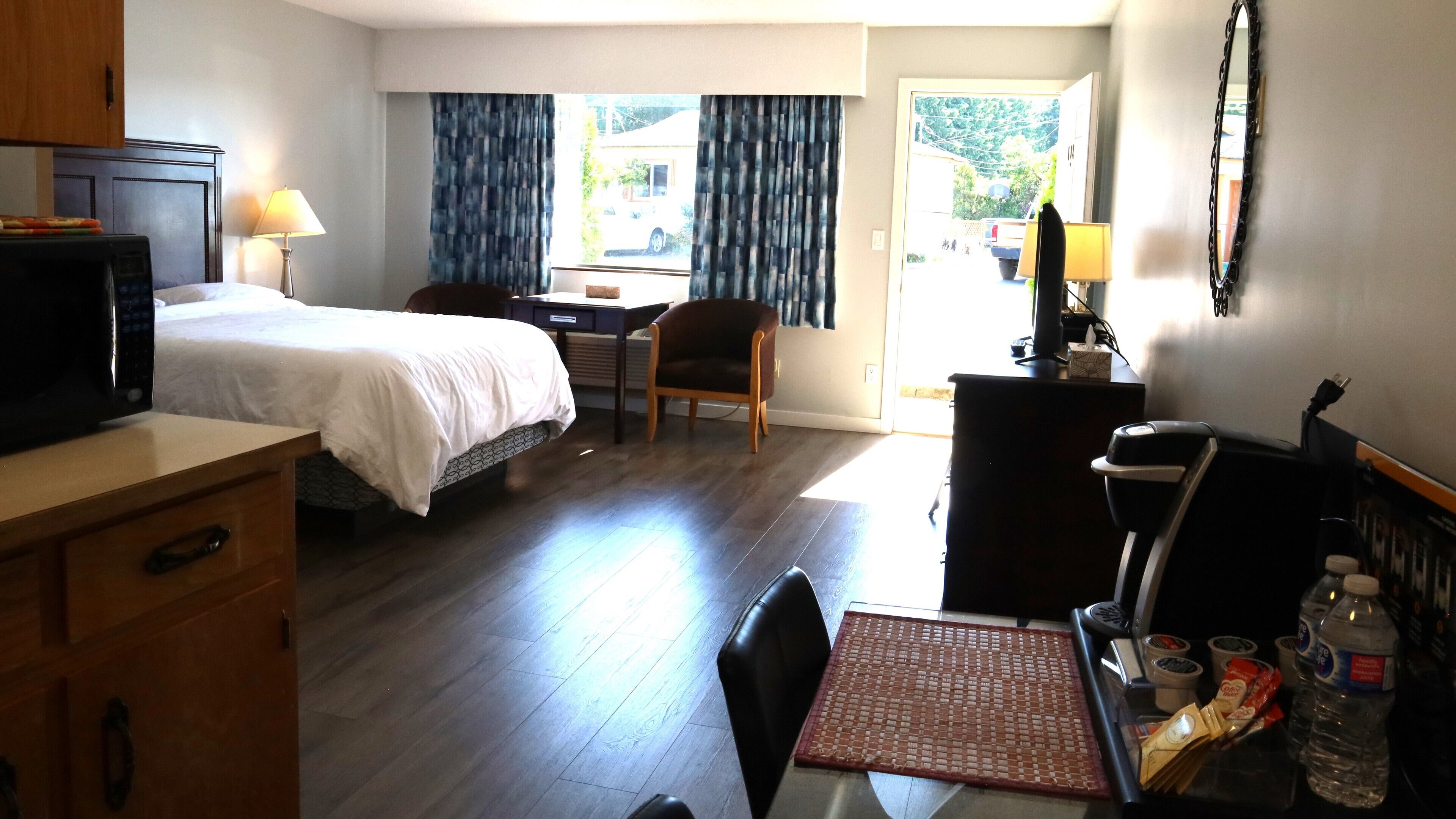 Una camera d'albergo con un letto, una scrivania, una sedia e un tavolo da pranzo.