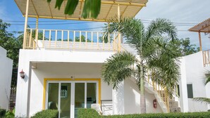A two-story building with a balcony, a glass door entrance, and a staircase leading to the upper level. - KeereeLay (Ko Lanta)
