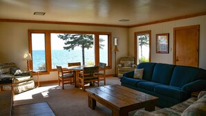 Un salon chaleureux avec vue sur la mer, des meubles en bois et un canapé bleu.