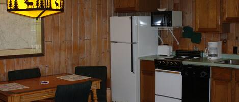 A kitchen with wooden cabinets, a refrigerator, a stove, a dishwasher, and a microwave.