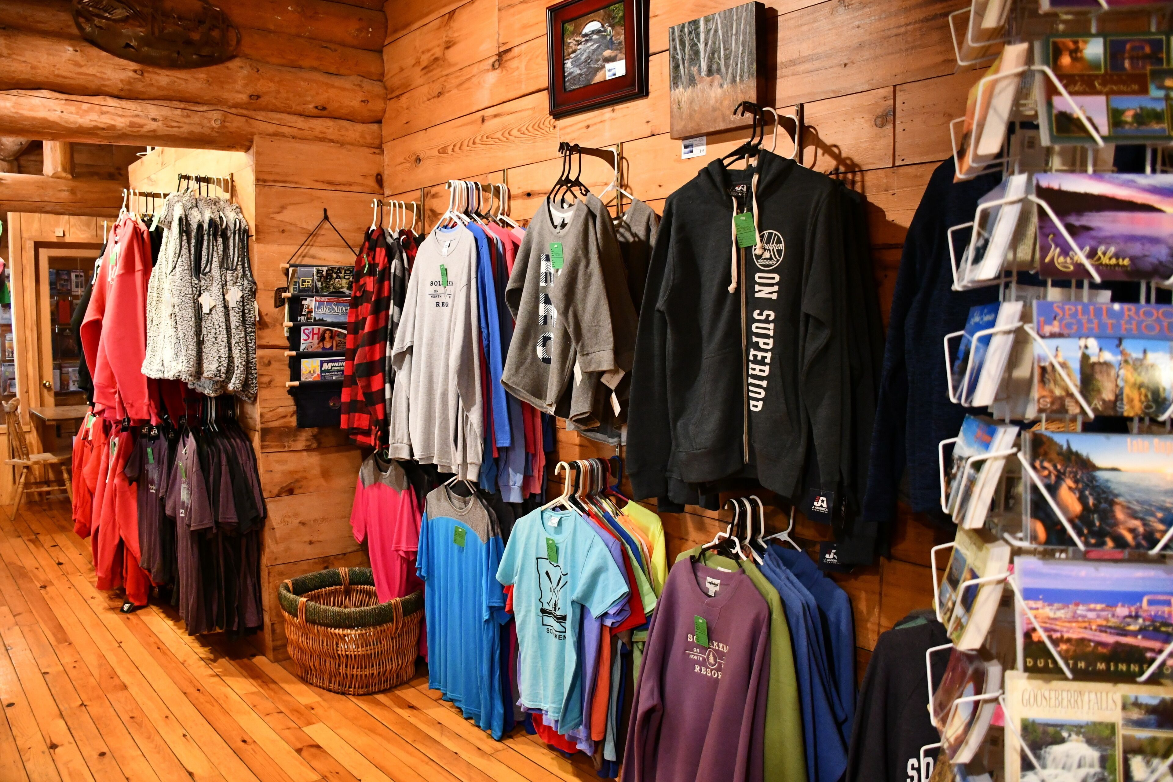 A clothing store with racks of various shirts and jackets.