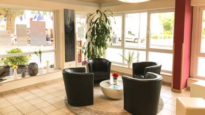 Ein modernes Interieur mit einer Sitzecke, großen Fenstern und einer Kristallleuchter.