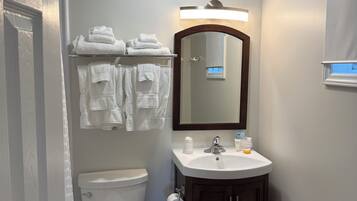 A bathroom with a toilet, sink, and mirror.