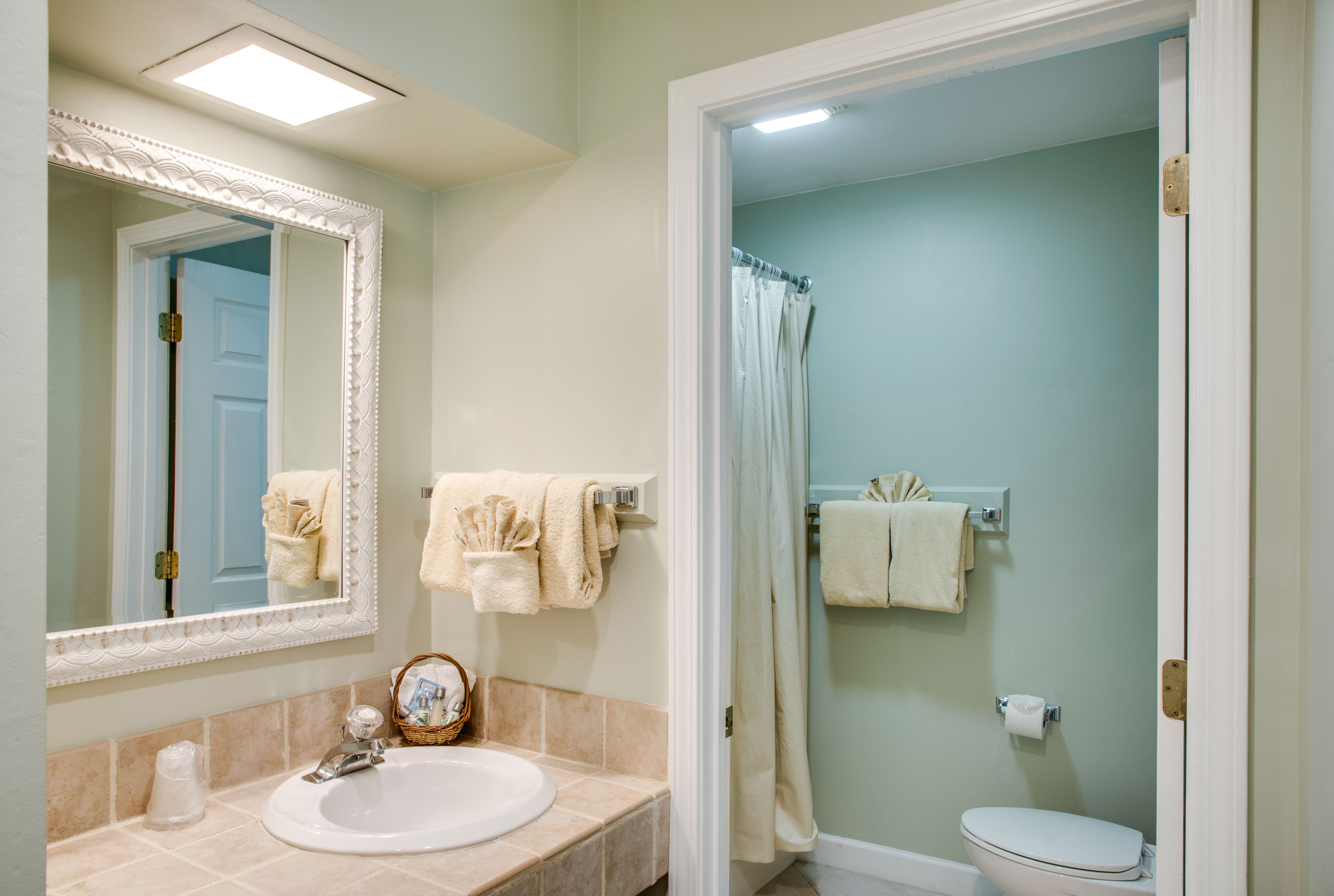 A bathroom with a sink, mirror, and toilet.
