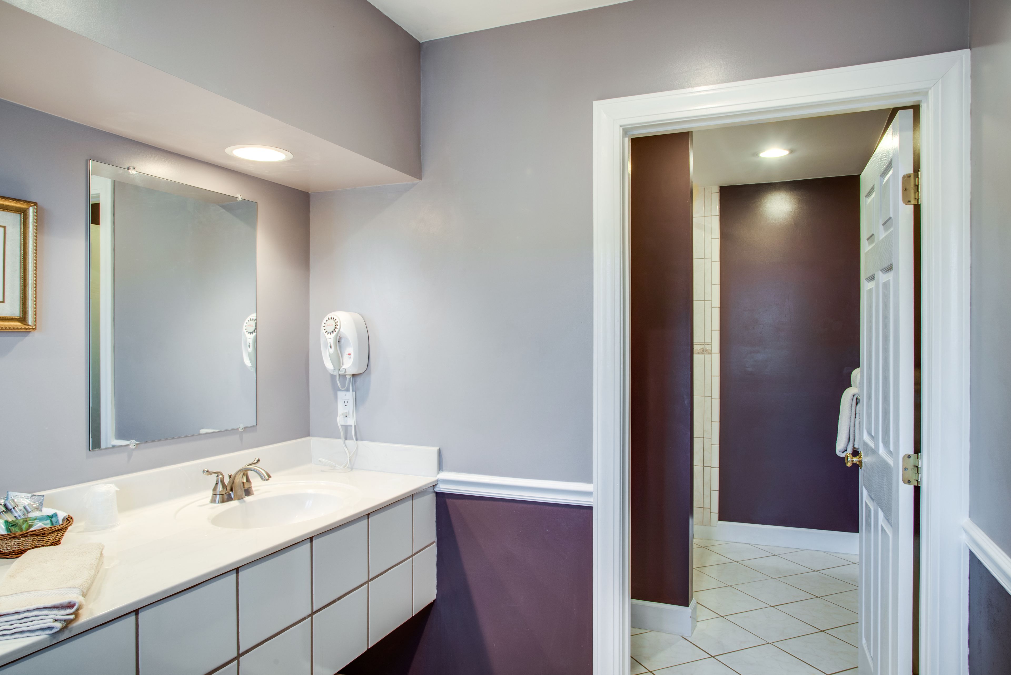 A bathroom with a double sink, a large mirror, and a towel rack.