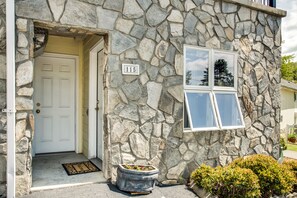 Un edificio de piedra con una puerta blanca, un buzón y una ventana.