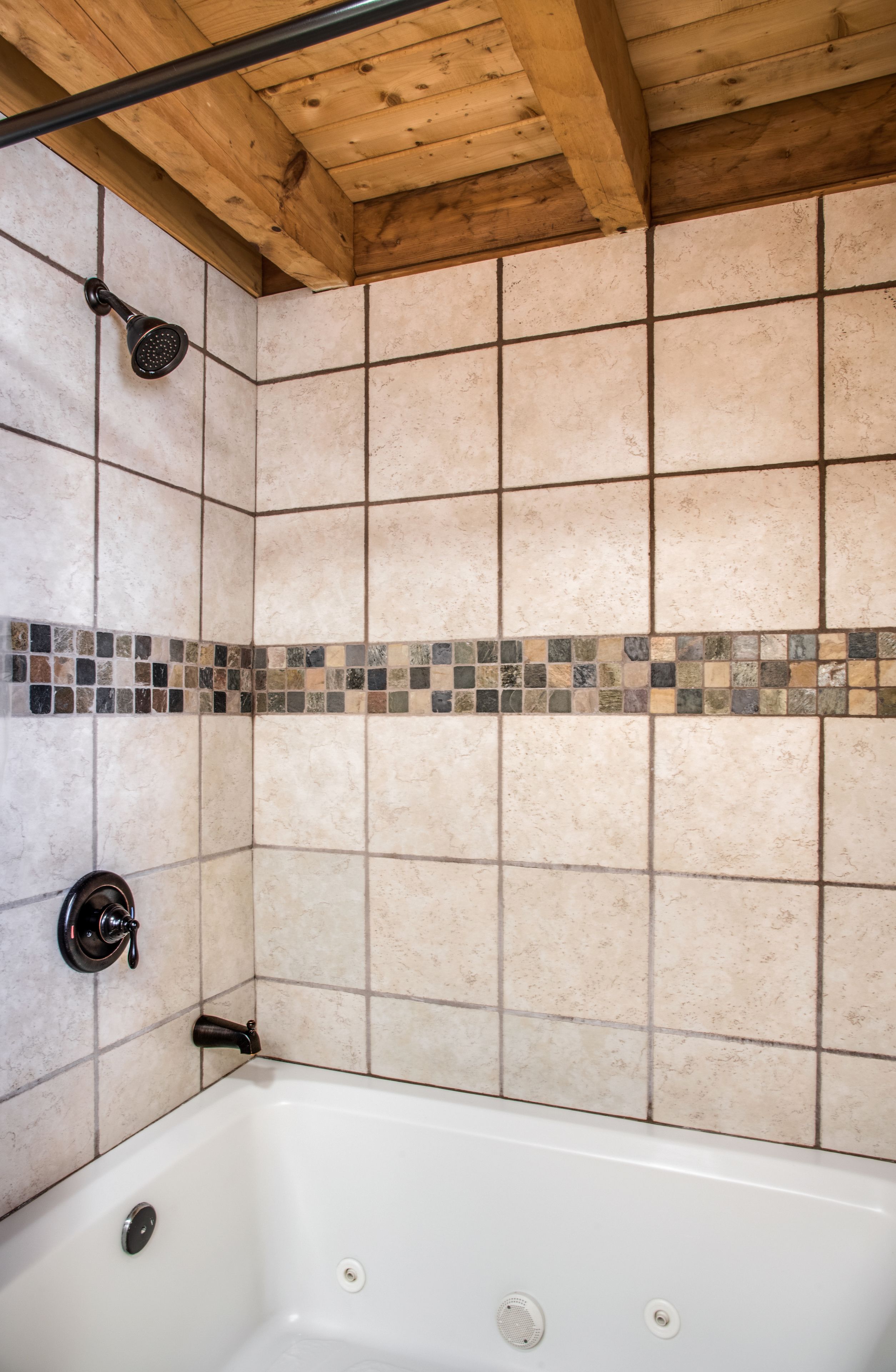 Un bagno con vasca, doccia e pareti piastrellate.