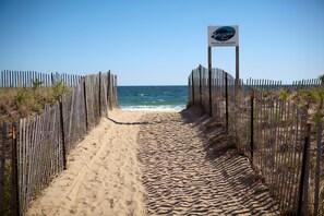 A beach path leading to the ocean with a sign indicating 'Private Beach - Pass Required'. - Breezeway Boutique Hotel (Westerly)