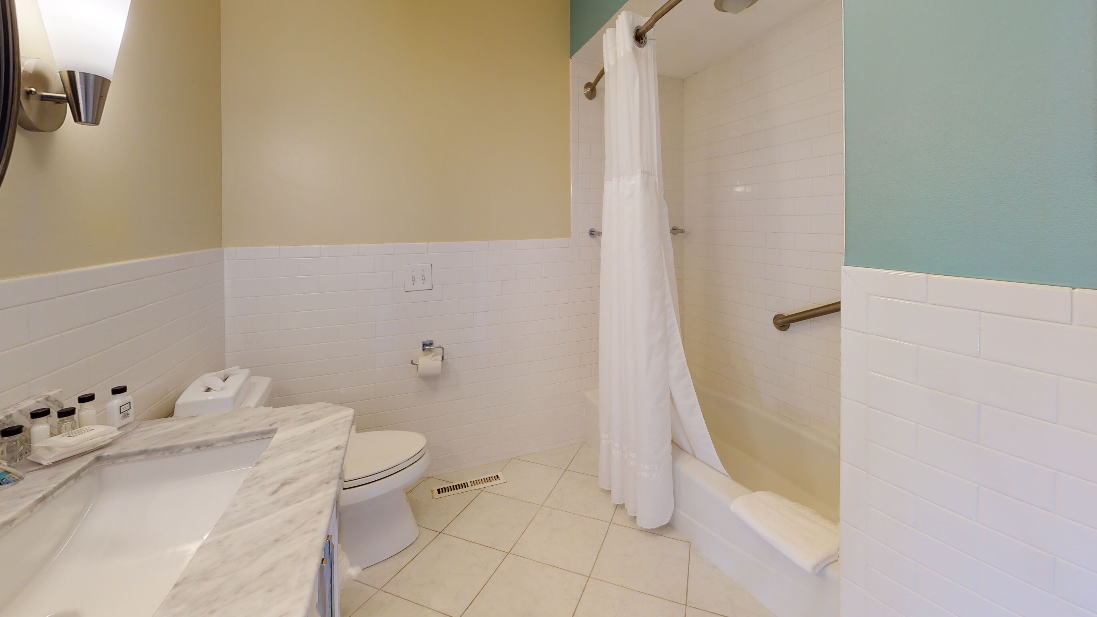 A bathroom with a toilet, sink, and bathtub.