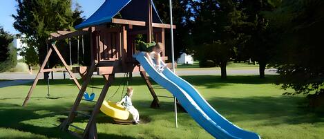 A playground with a slide and swings.