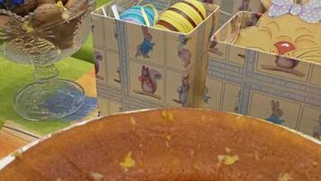 Una mesa con un pastel, un bol de galletas y una caja con un diseño de conejo.