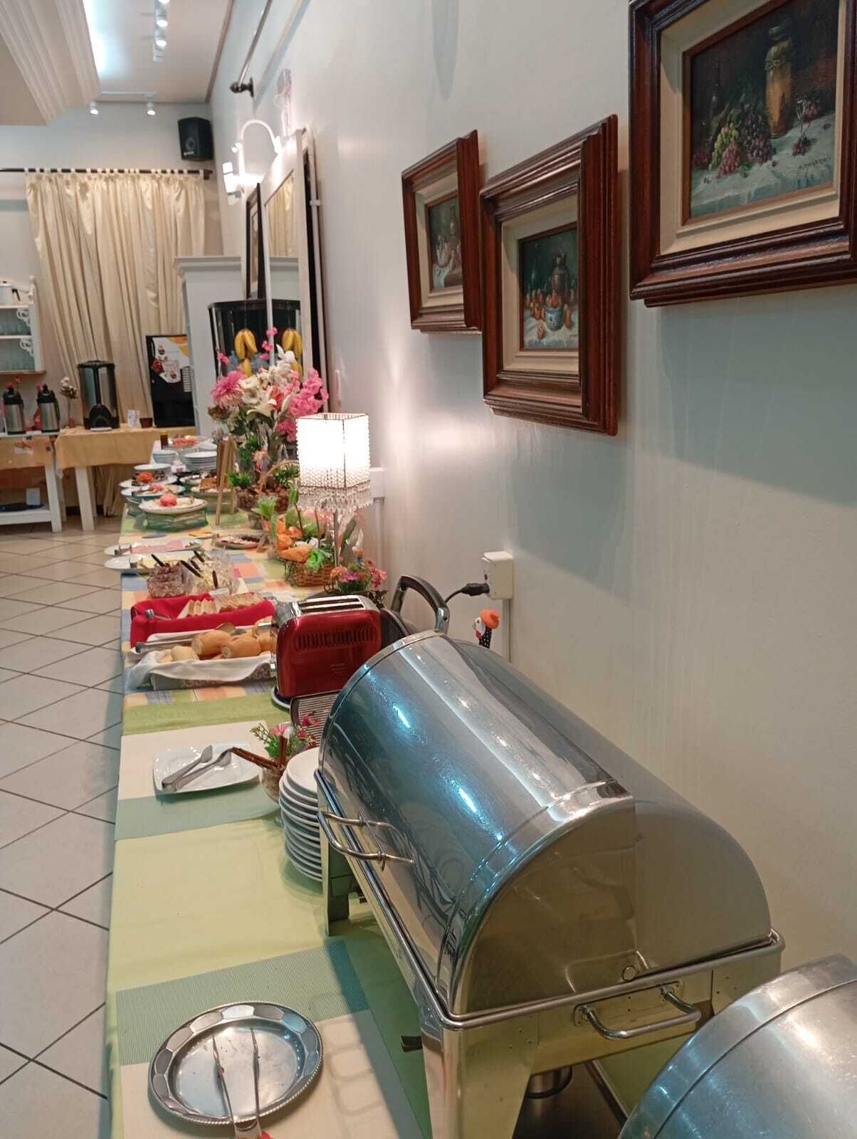 Montaje de bufé con diversos alimentos y una amplia cubierta plateada.