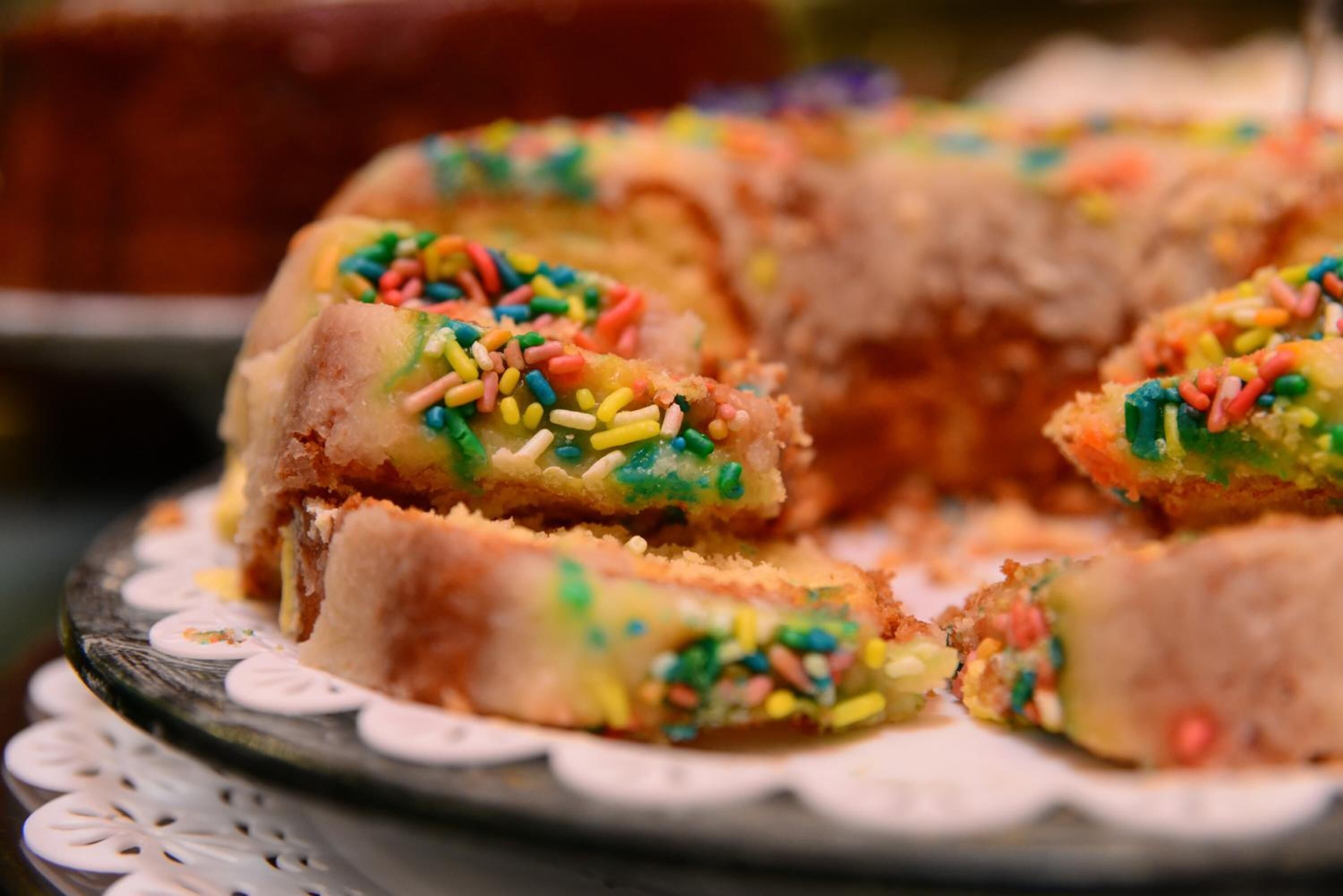 Un plato de pasteles coloridos espolvoreados.