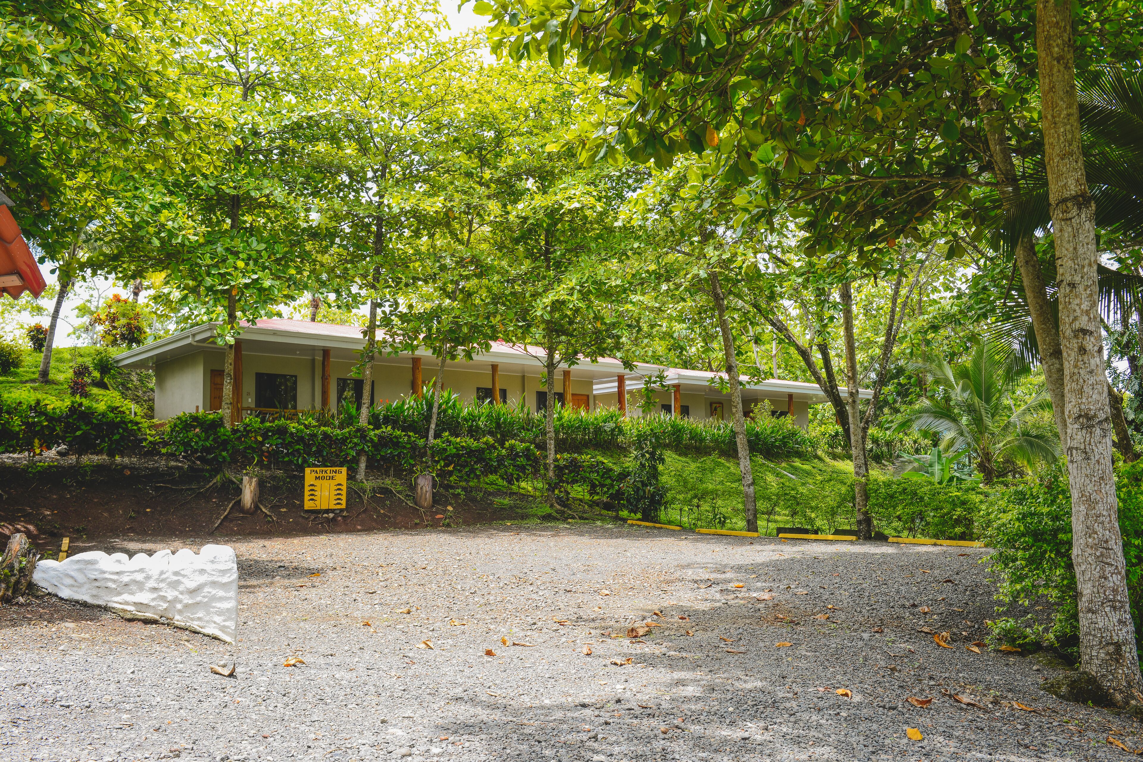 A building with a gravel driveway and a parking sign.