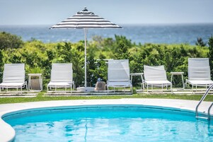 Una piscina al aire libre, sombrillas, tumbonas
