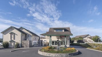 Stunning two-story building with a flat roof and inviting entrance, set amidst a beautifully landscaped area with a small fountain.