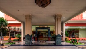 A hotel entrance with a central archway, columns, and a ceiling fan. - Phi Semesta (Semarang)
