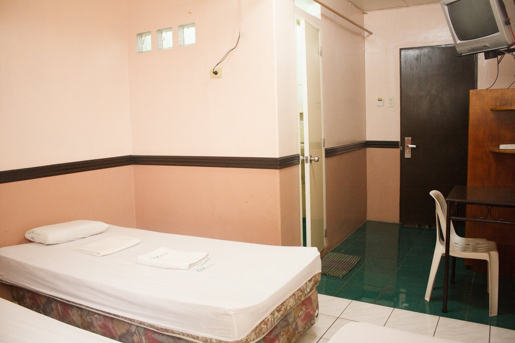 A room with a bed, a desk, and a chair.