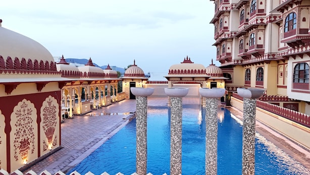 A pool area with tiled pillars and ornate architecture.