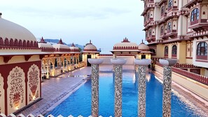A pool area with tiled pillars and ornate architecture.