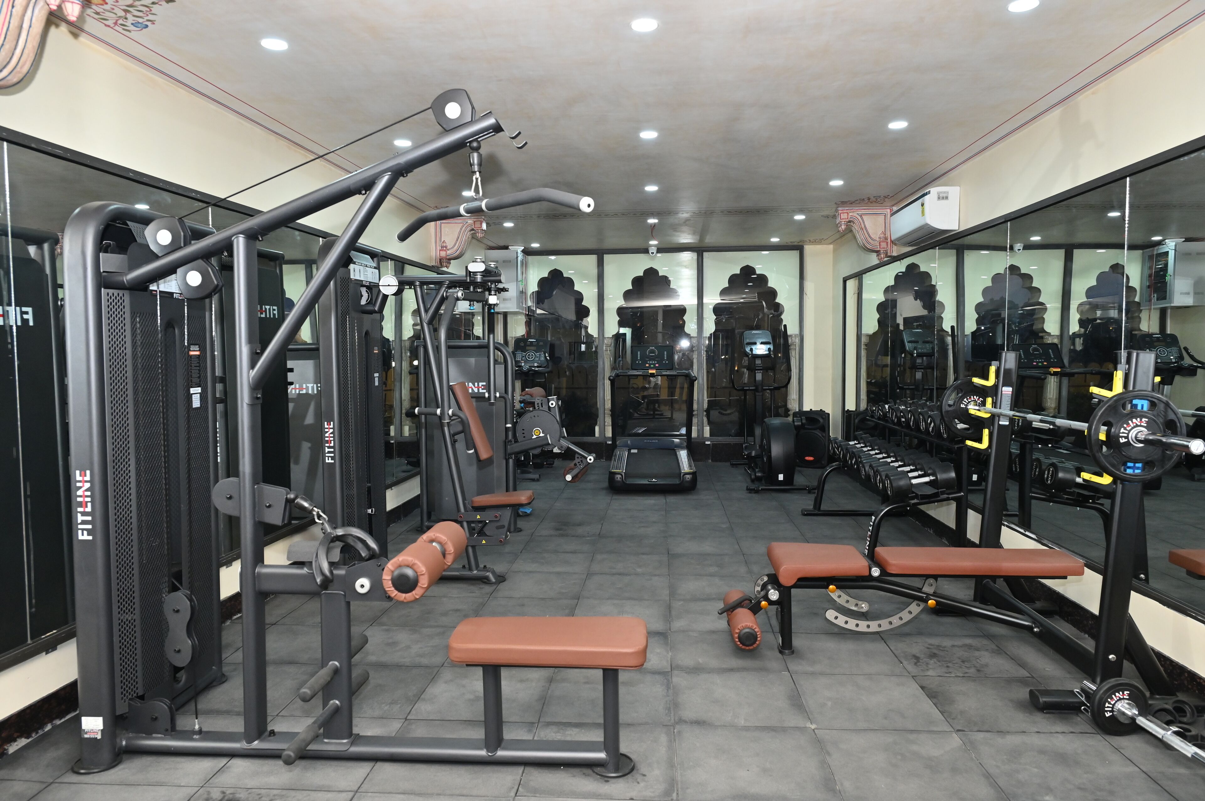 A gym with various exercise equipment, benches, and weightlifting stations.