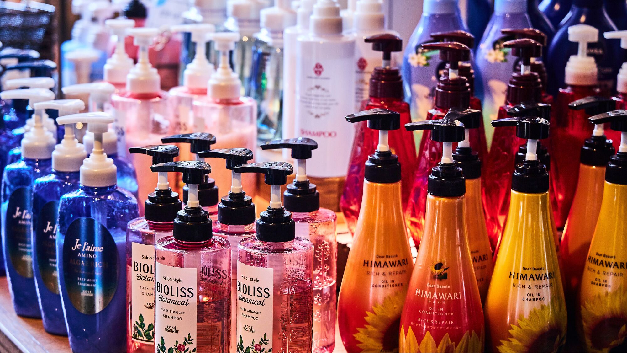 A variety of shampoo bottles on a shelf.