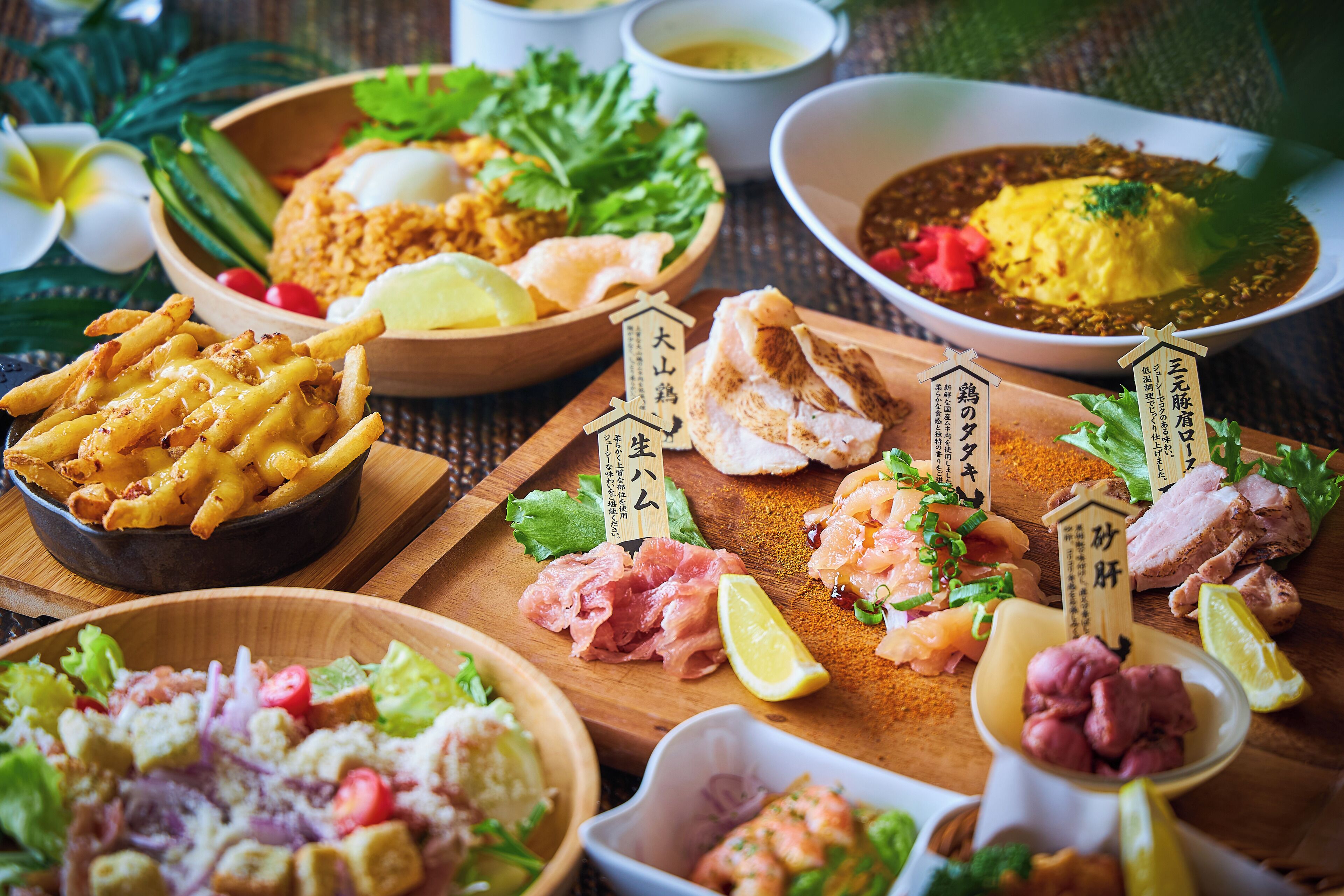 A variety of dishes including seafood, fried items, and salads, arranged on a wooden table.