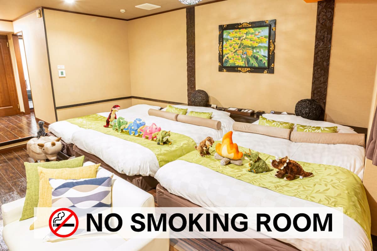 Ein Hotelzimmer mit zwei Betten, einem Rauchverbotsschild und einem Bild an der Wand.