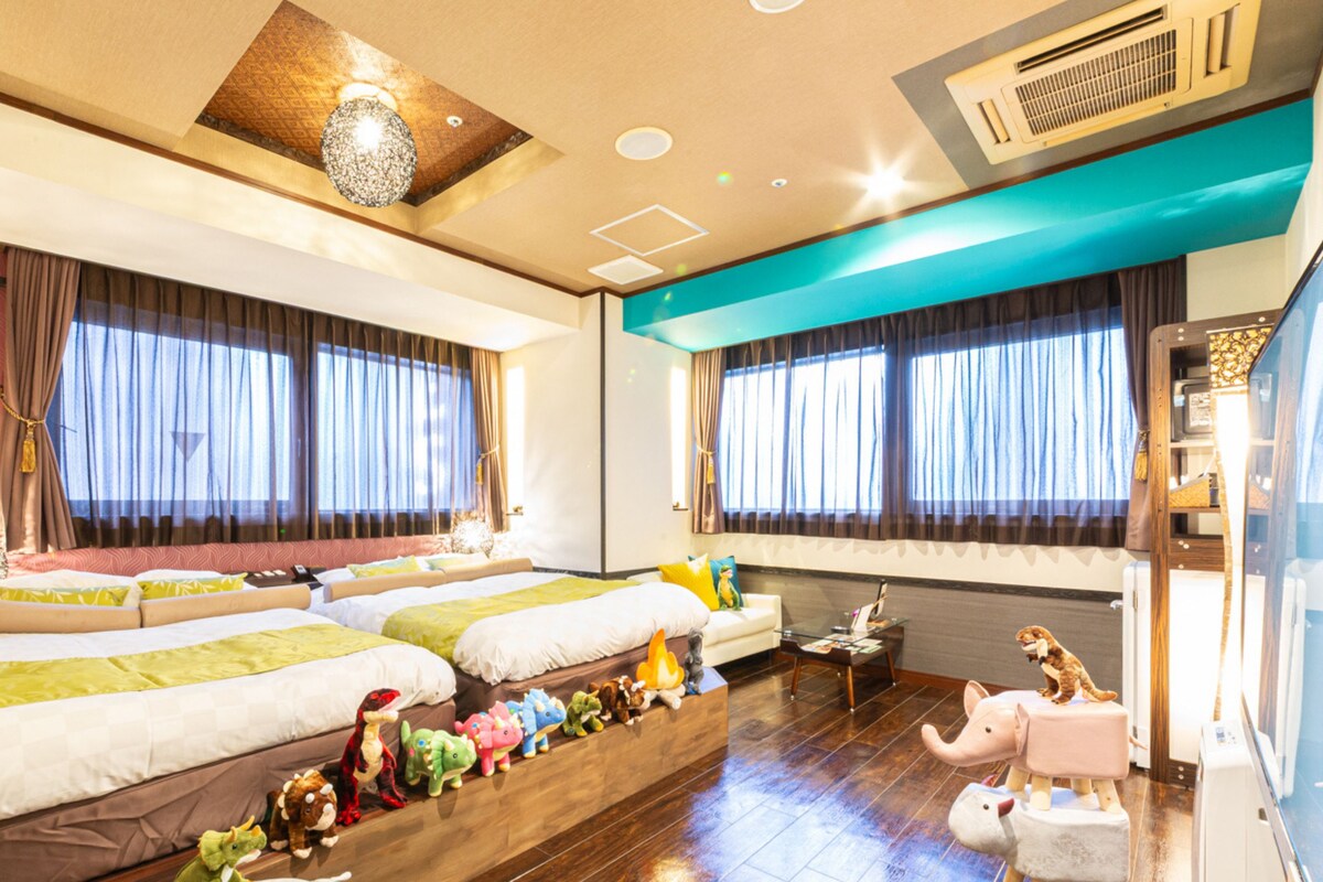 A hotel room with a no smoking sign, a sofa, a bed, and a window with curtains.