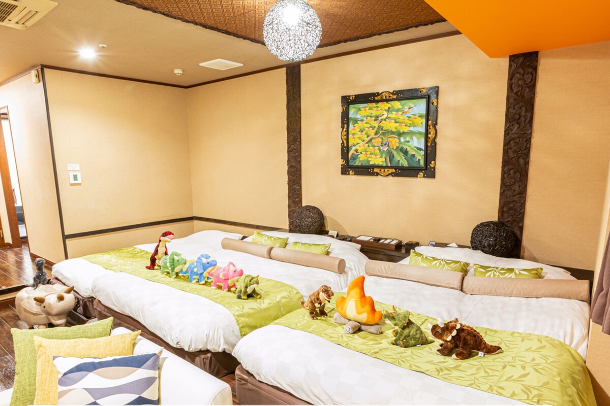 A hotel room with two beds, a no-smoking sign, and a painting on the wall.
