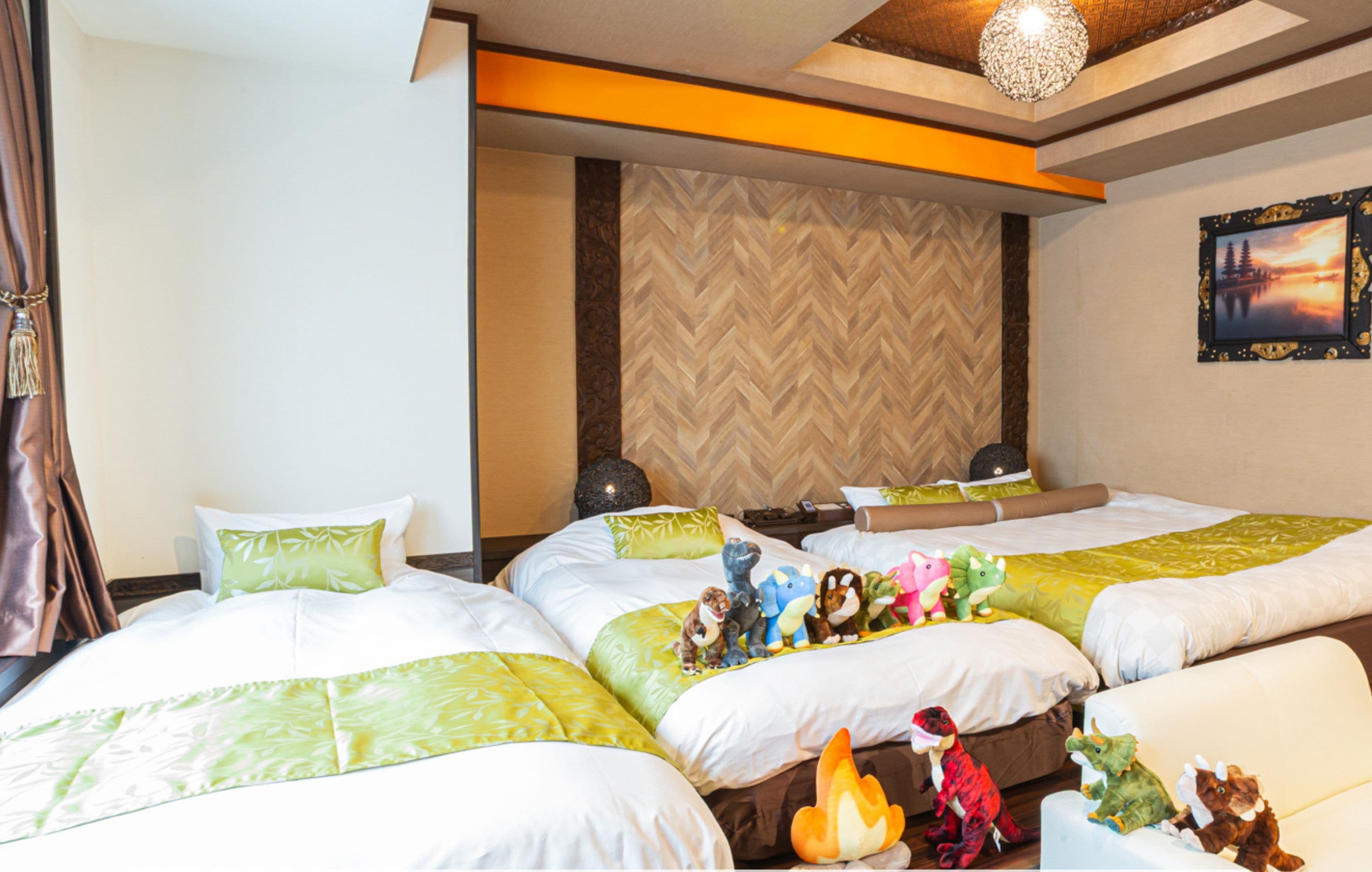 A hotel room with two beds, a no smoking sign, and dinosaur toys on the beds.
