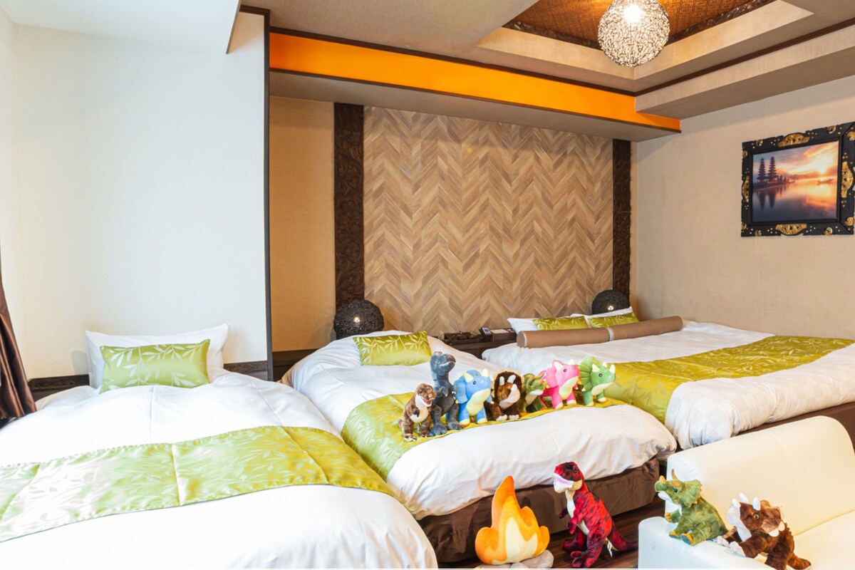 A hotel room with two beds, a no smoking sign, and dinosaur toys on the beds.