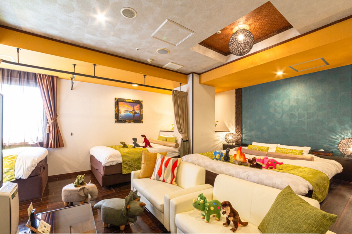 A hotel room with a sofa, a bed, and a 'No Smoking' sign.