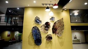 Ein modernes Interieur mit einer gelben Wand, die mit abstrakten Kunstwerken geschmückt ist.