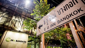 Ein Schild für 'INN Bangkok' mit einem nach links zeigenden Pfeil, der den Weg zum Hotel anzeigt.