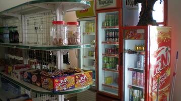 A store with multiple shelves stocked with snacks, beverages, and canned goods.