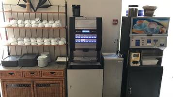 A coffee machine with a digital display, a coffee dispenser, and a small refrigerator with a coffee cup display.