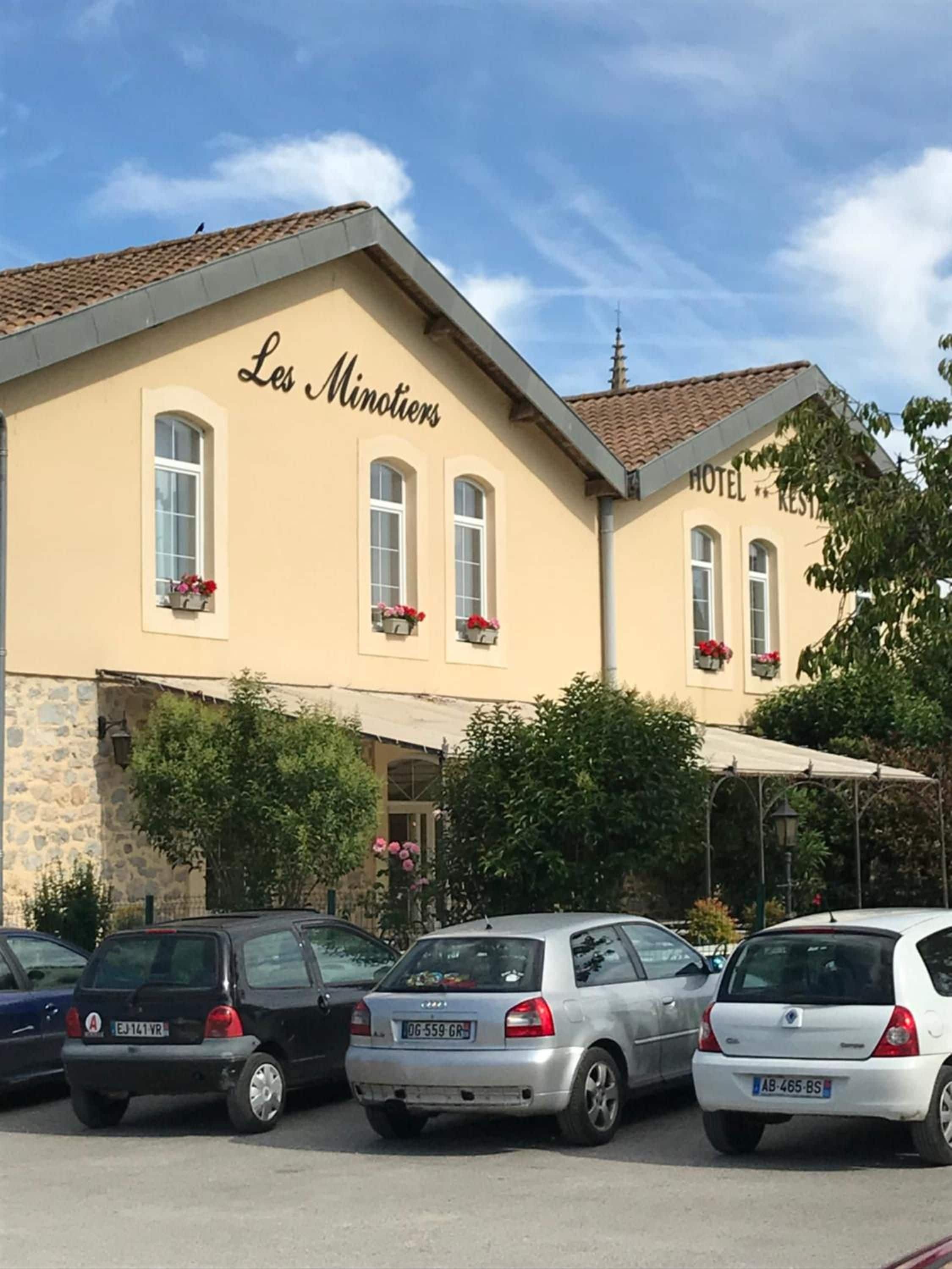 Un bâtiment portant l’enseigne « Les Minotiers » et la mention « HÔTEL-RESTAURANT », indiquant qu’il s’agit d’un établissement proposant à la fois un restaurant et un hôtel.