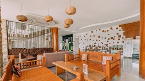 A modern interior with wooden furniture, a seating area, and a decorative wall. - The Salak Hotel (Denpasar)