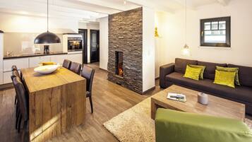 A modern living space with a dining area, a fireplace, a sofa with cushions, and a coffee table.