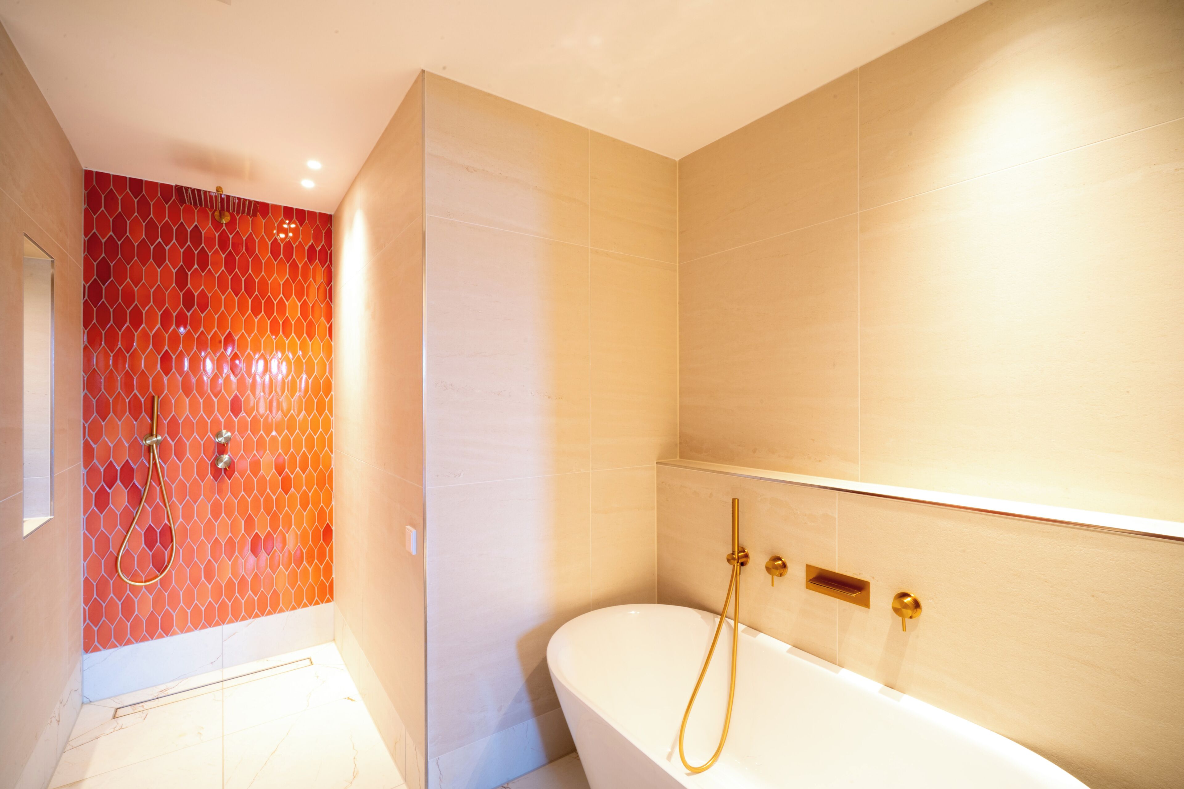 A modern bathroom with a shower, a bathtub, and a tiled wall.