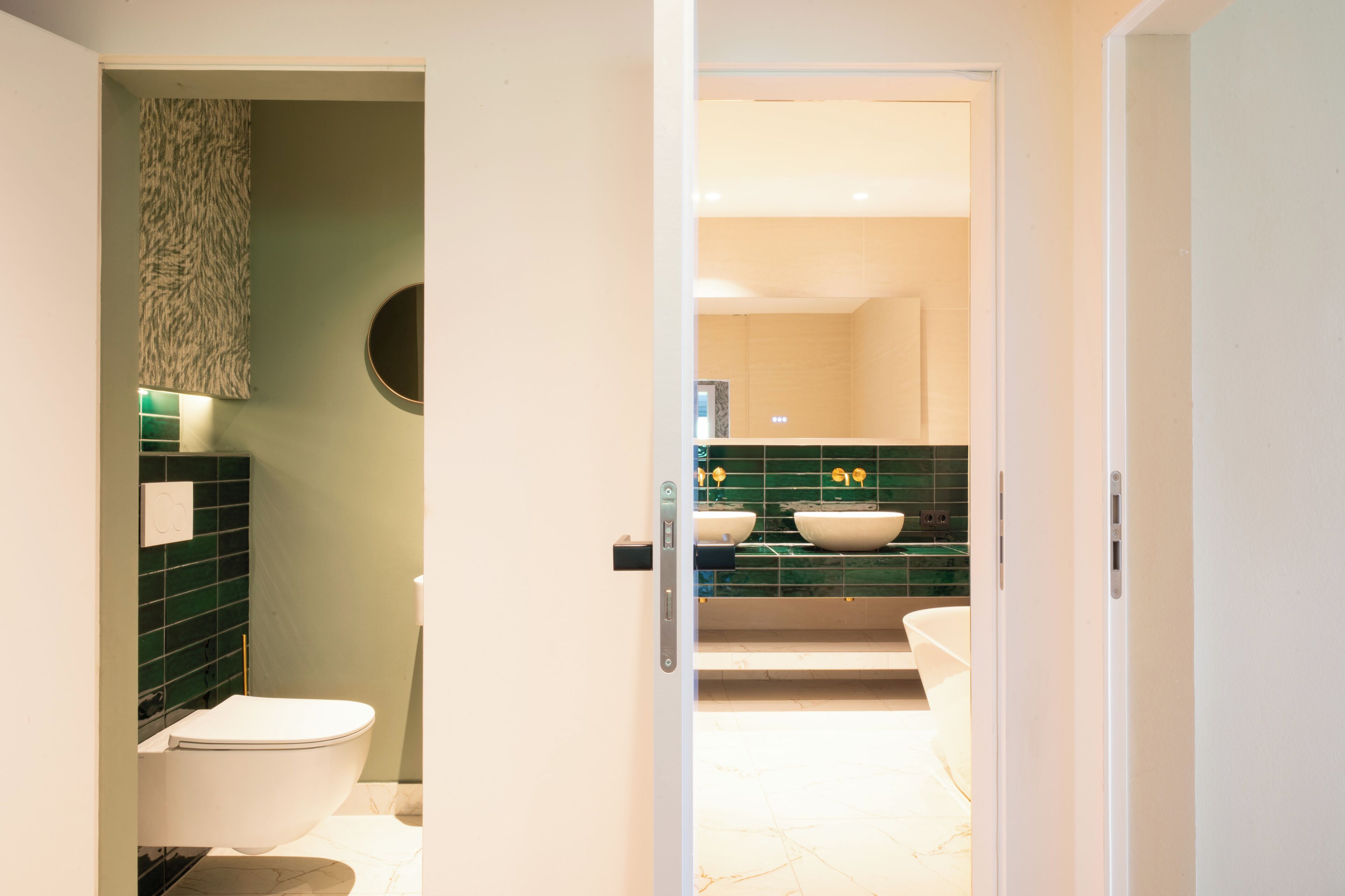 A bathroom with a toilet, a sink, and a mirror.