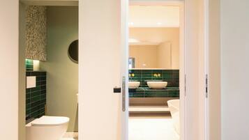 A bathroom with a toilet, a sink, and a mirror.