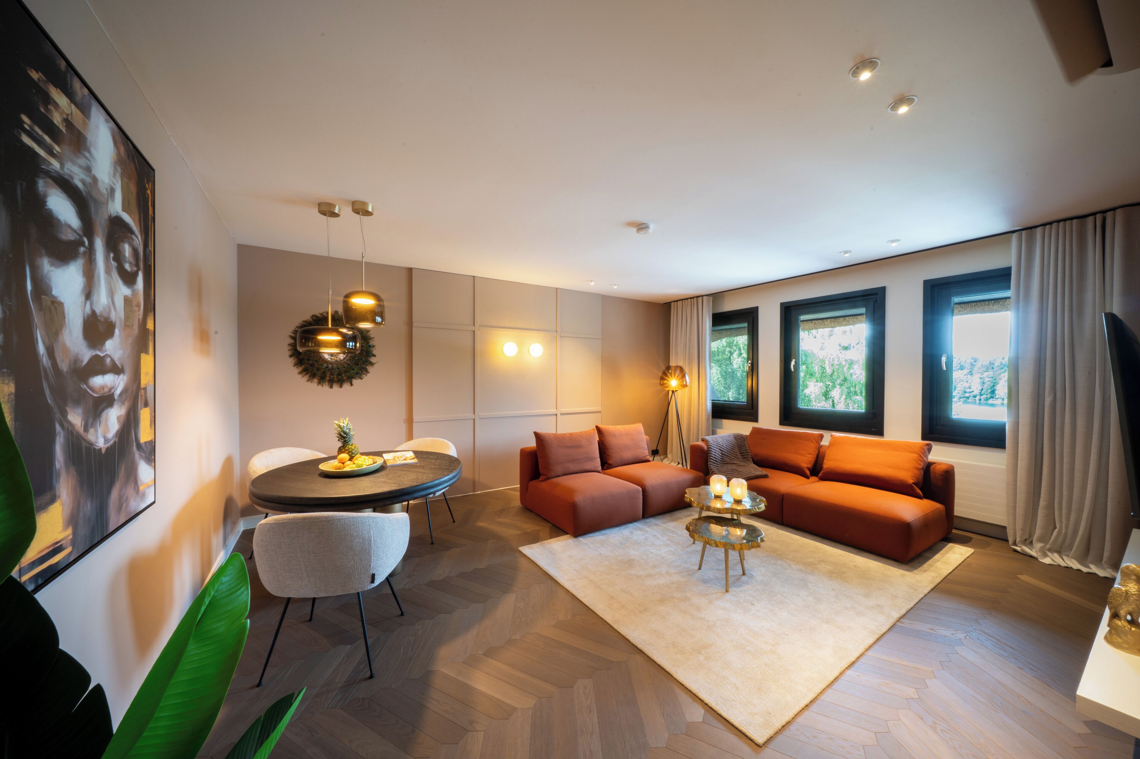 Ein modernes Wohnzimmer mit einer Couch, einem runden Tisch und einem Fernseher.