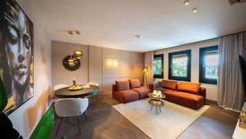 Ein modernes Wohnzimmer mit einer Couch, einem runden Tisch und einem Fernseher.