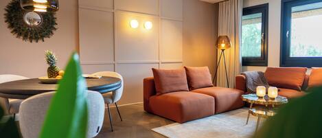 A modern living room with a sofa, a dining table, and a floor lamp.