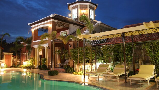 A luxurious resort with a swimming pool, lounge chairs, and a tower with a balcony. - Budsaba Resort & Spa (Bang Lamung)